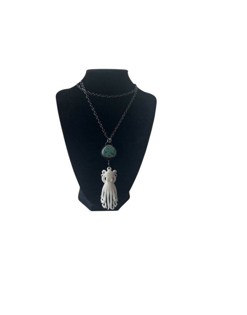 The Silver Necklace with Turquoise & Kraken Pendant is a bold, statement piece that combines intricate silver craftsmanship with a striking turquoise stone and a mystical Kraken-inspired pendant. Its unique design adds a touch of fantasy and bohemian flair, making it a standout accessory for those seeking something distinctive and eye-catching.