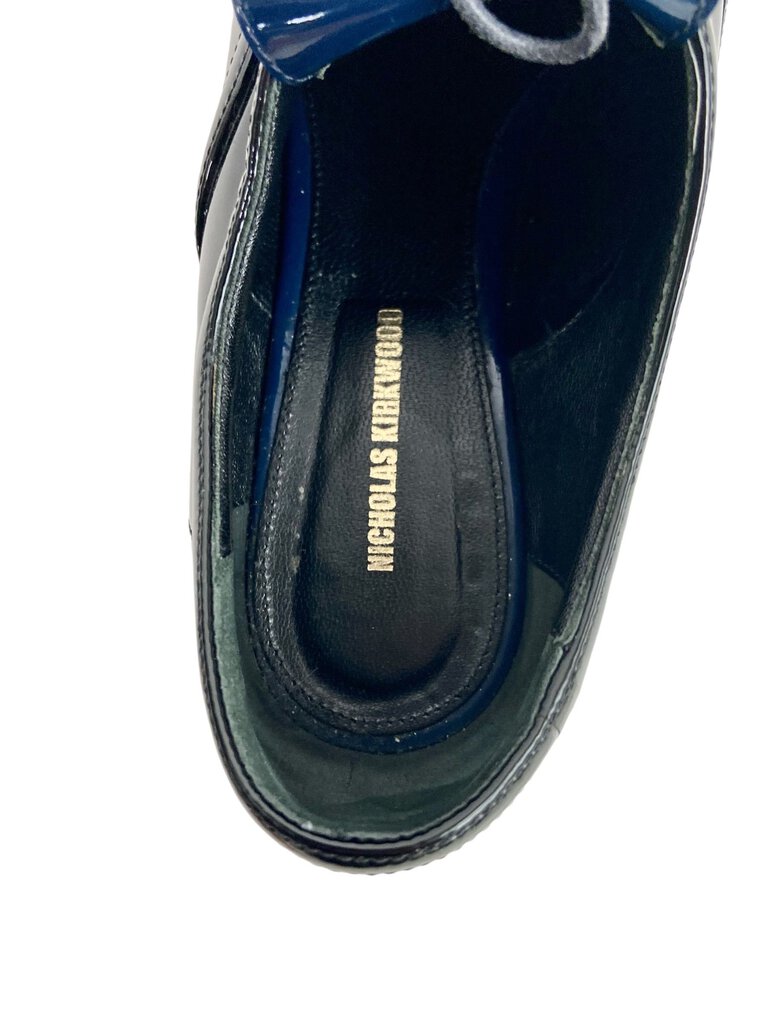 The Nicholas Kirkwood Patent Color Block Loafers are a striking blend of classic and contemporary style, featuring a sleek patent finish and bold color blocking. With their chic design and comfortable fit, these loafers add a fashionable touch to both casual and tailored looks.