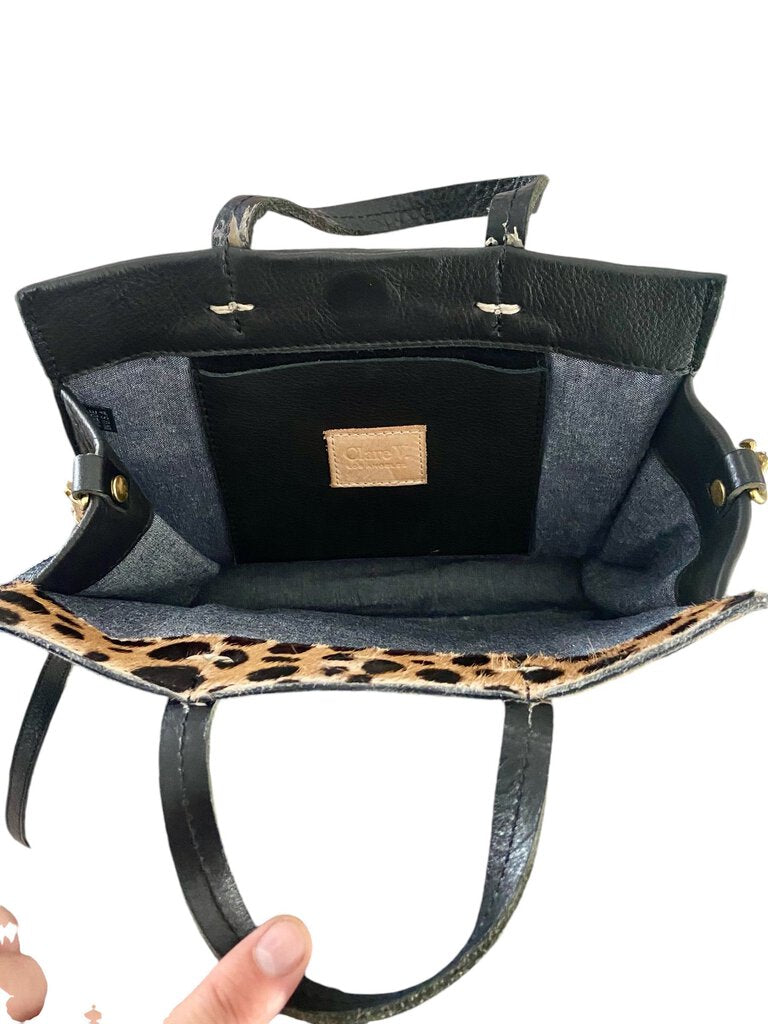 The Clare V Pieced Leopard Crossbody Bag is a striking accessory that combines different textures and prints for a playful yet sophisticated look. Its adjustable strap and compact design make it both functional and stylish, perfect for adding a touch of wild elegance to any outfit.