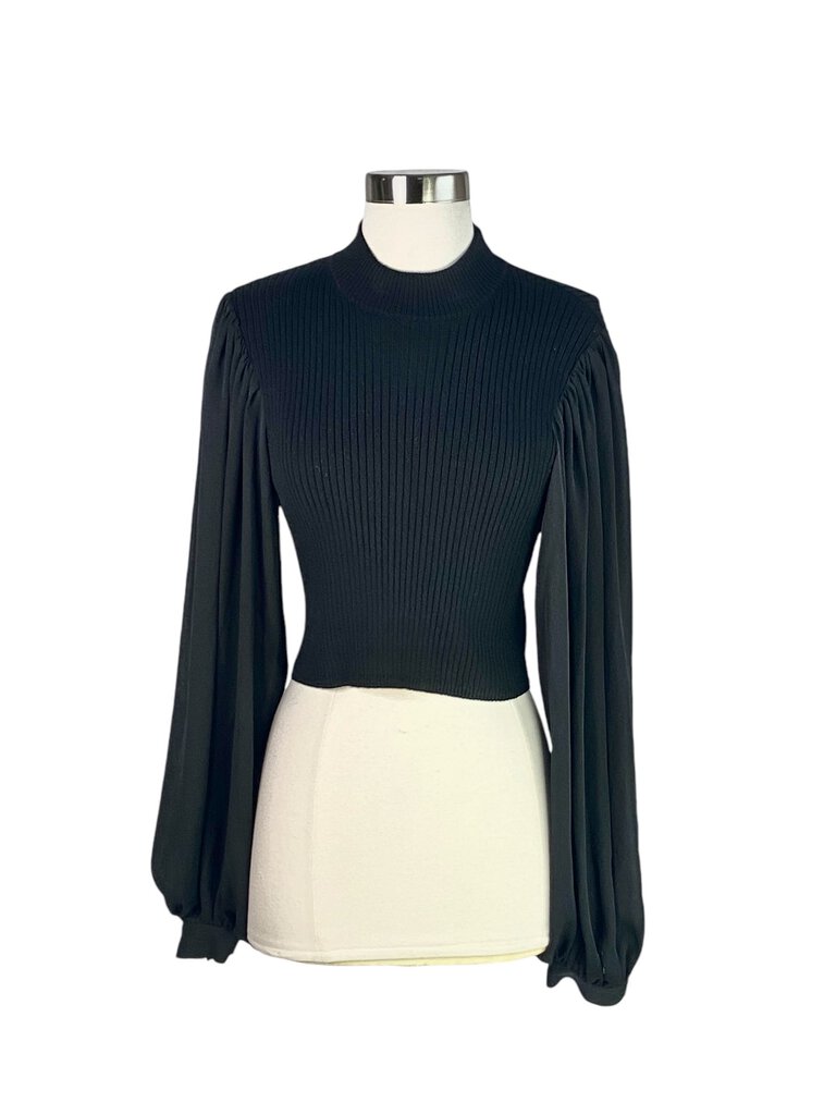 The Ronny Kobo Balloon Sleeve Ribbed Cropped Sweater is a trendy and stylish piece, featuring dramatic balloon sleeves and a ribbed texture that adds depth and dimension. Its cropped length makes it perfect for pairing with high-waisted bottoms, creating a chic silhouette for any occasion.