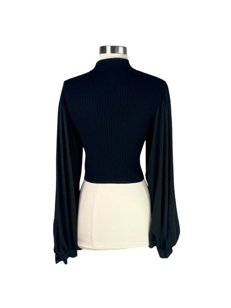 The Ronny Kobo Balloon Sleeve Ribbed Cropped Sweater is a trendy and stylish piece, featuring dramatic balloon sleeves and a ribbed texture that adds depth and dimension. Its cropped length makes it perfect for pairing with high-waisted bottoms, creating a chic silhouette for any occasion.