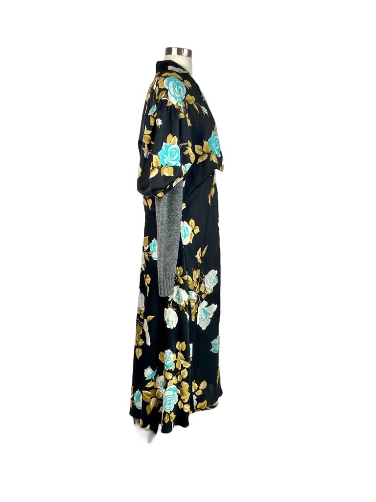 The Comme des Garçons Knit Contrast Floral Crepe Maxi Dress combines bold, contemporary design with a feminine flair, featuring a flowing crepe fabric adorned with vibrant floral patterns. The contrasting knit details add texture and dimension, creating a striking, avant-garde silhouette that's perfect for making a statement at any occasion.