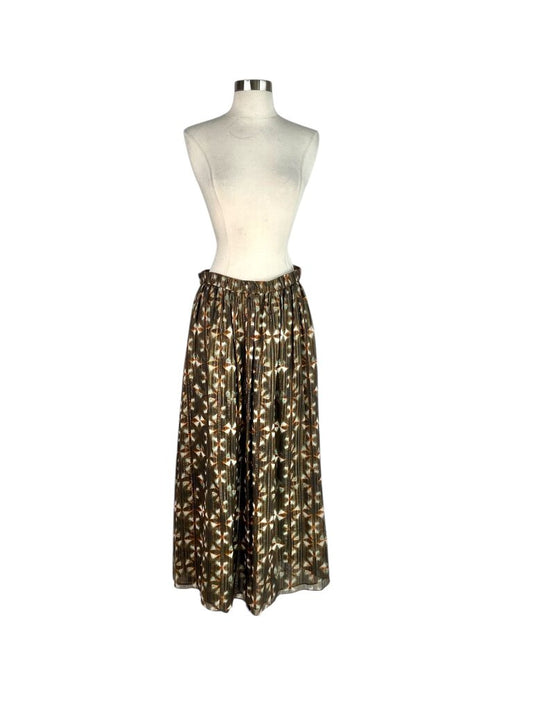 The Ulla Johnson Metallic Tie Dye Gathered Maxi Skirt features a stunning blend of metallic hues and a soft tie-dye pattern, creating a rich, eye-catching effect. Its gathered silhouette offers a relaxed yet flattering fit, making it a versatile piece that adds bohemian elegance and a touch of shimmer to any wardrobe.