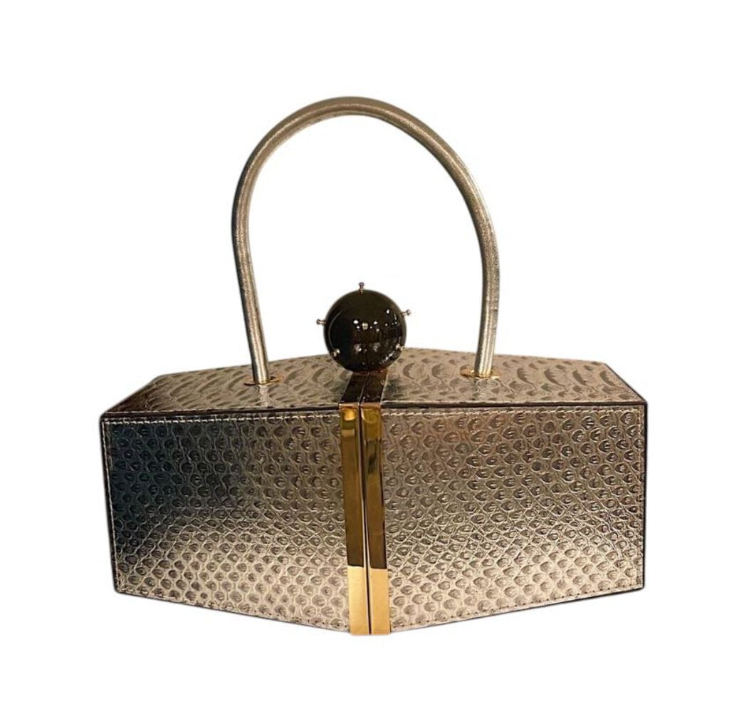 The Tonya Hawkes Embossed Snake Clutch Bag is a luxurious statement accessory, featuring a bold embossed snake pattern on high-quality leather. Accented with signature sculptural hardware, it blends exotic elegance with contemporary design.