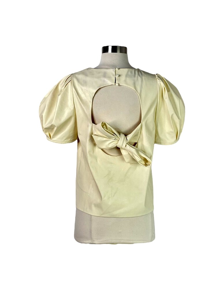 The Tanya Taylor Faux Leather Back Bow Blouse combines a chic, structured front with a playful faux leather bow detail at the back, creating a modern yet feminine silhouette. Its luxurious fabric and unique design make it a standout piece for both day and evening wear.