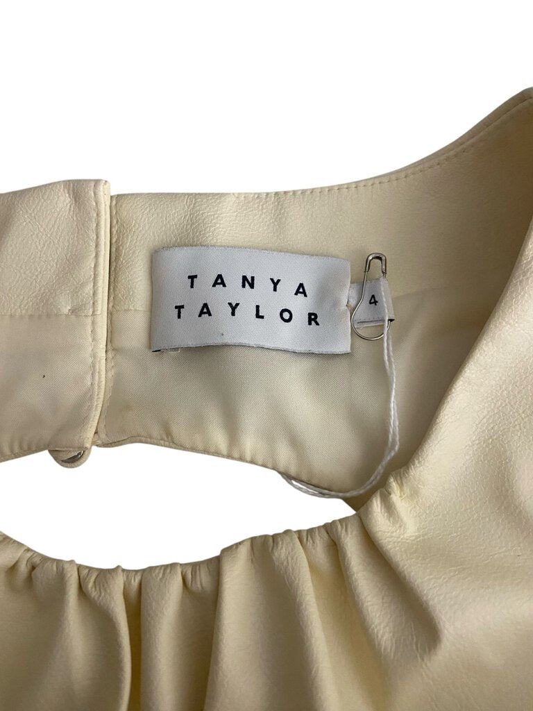 The Tanya Taylor Faux Leather Back Bow Blouse combines a chic, structured front with a playful faux leather bow detail at the back, creating a modern yet feminine silhouette. Its luxurious fabric and unique design make it a standout piece for both day and evening wear.