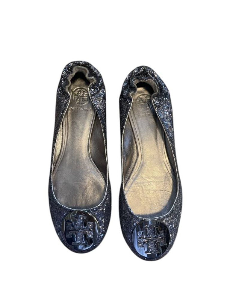 Tory Burch Glitter Flats are a glamorous yet versatile footwear option, featuring a sparkling glitter finish that adds a touch of elegance to any outfit. Finished with the signature Tory Burch logo, these flats offer a blend of style and comfort for everyday wear or special occasions.