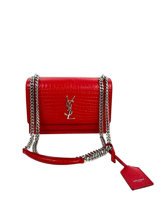 The Saint Laurent Calfskin Crocodile Embossed Medium Monogram Sunset Rouge Eros Handbag exudes luxury with its rich, crocodile-embossed calfskin leather and iconic YSL monogram plaque. The striking rouge Eros color adds a bold, timeless appeal, while its medium size offers a perfect balance of elegance and practicality for day or night.