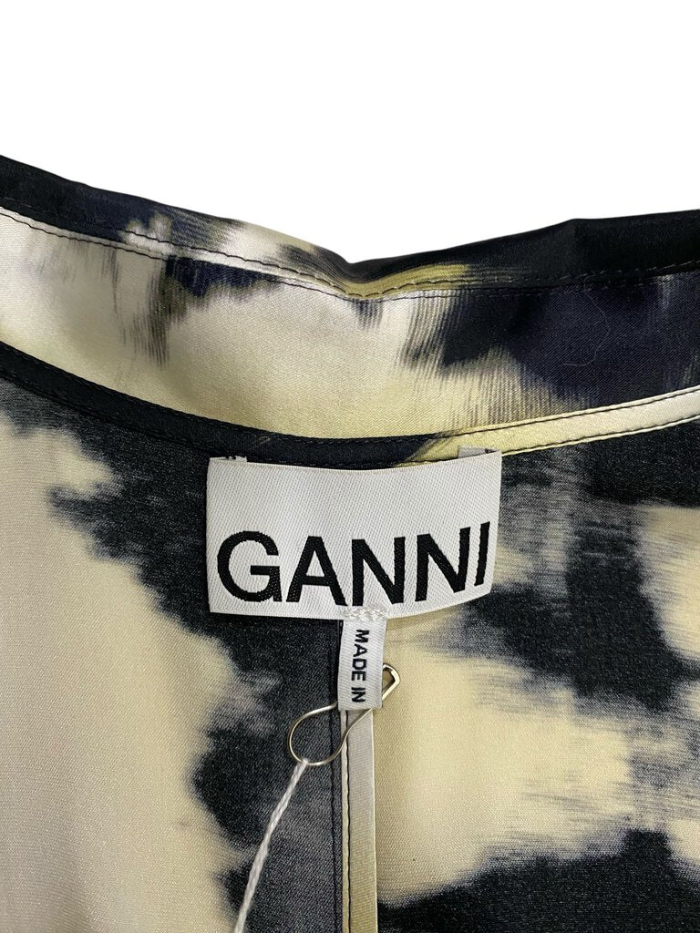 The Ganni Silk Ruched Abstract Print Midi Dress features a luxurious silk fabric adorned with an eye-catching abstract print. With its flattering ruching and midi-length silhouette, this dress effortlessly combines elegance and contemporary style for a bold yet feminine look.