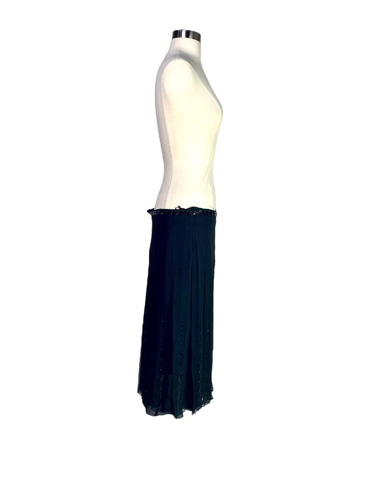 The Chloe Silk Georgette Beaded Midi Skirt features a flowy, ethereal silhouette crafted from luxurious silk georgette, adorned with delicate beading for a touch of glamour. Its midi length and soft drape make it a versatile piece, perfect for elevating both casual and formal looks with understated elegance.