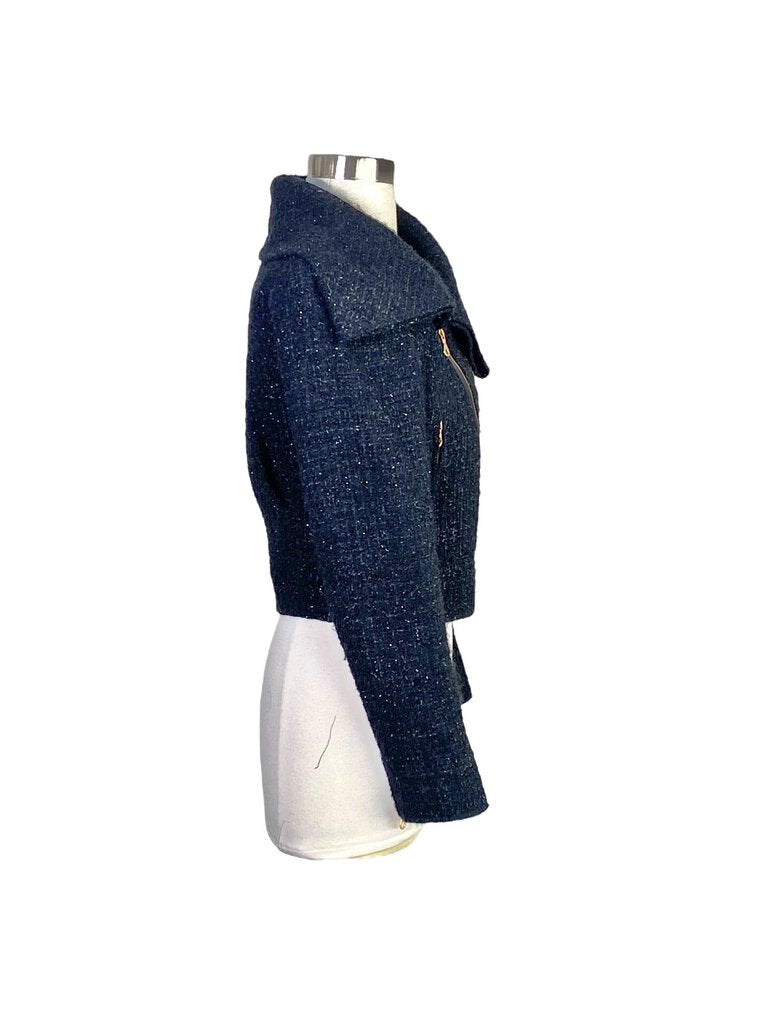 The Oscar de la Renta Wool Bouclé Moto Jacket merges classic moto style with refined luxury, featuring a rich wool bouclé fabric and intricate detailing. Its tailored fit, asymmetric zip closure, and chic structure make it a standout piece, adding a touch of elegance and edge to any wardrobe.