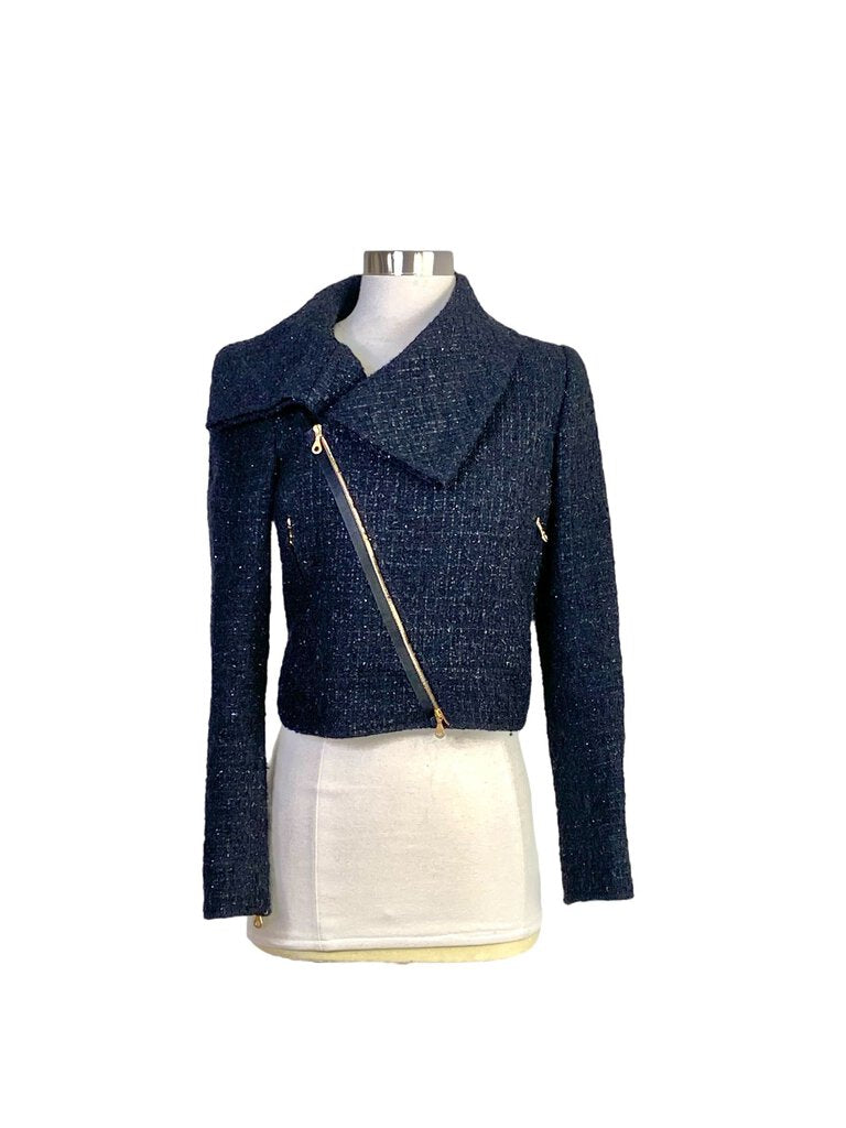 The Oscar de la Renta Wool Bouclé Moto Jacket merges classic moto style with refined luxury, featuring a rich wool bouclé fabric and intricate detailing. Its tailored fit, asymmetric zip closure, and chic structure make it a standout piece, adding a touch of elegance and edge to any wardrobe.