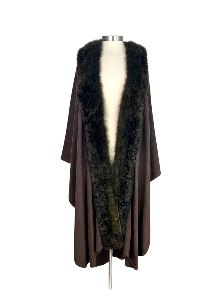 The Peruvian Connection Wool Cape with Baby Alpaca Border is a luxurious, soft layering piece crafted from warm wool and accented with a delicate baby alpaca trim. Its loose, flowing design and sophisticated details make it an elegant and cozy addition to any wardrobe, ideal for both casual and refined outfits.