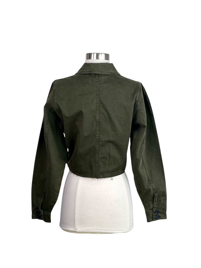 The Frame Cropped Utility Jacket features a chic, boxy silhouette with utilitarian details like oversized pockets and a waist-cinching belt. Made from durable cotton, it adds an effortlessly cool, military-inspired edge to any outfit while maintaining a modern, cropped length.